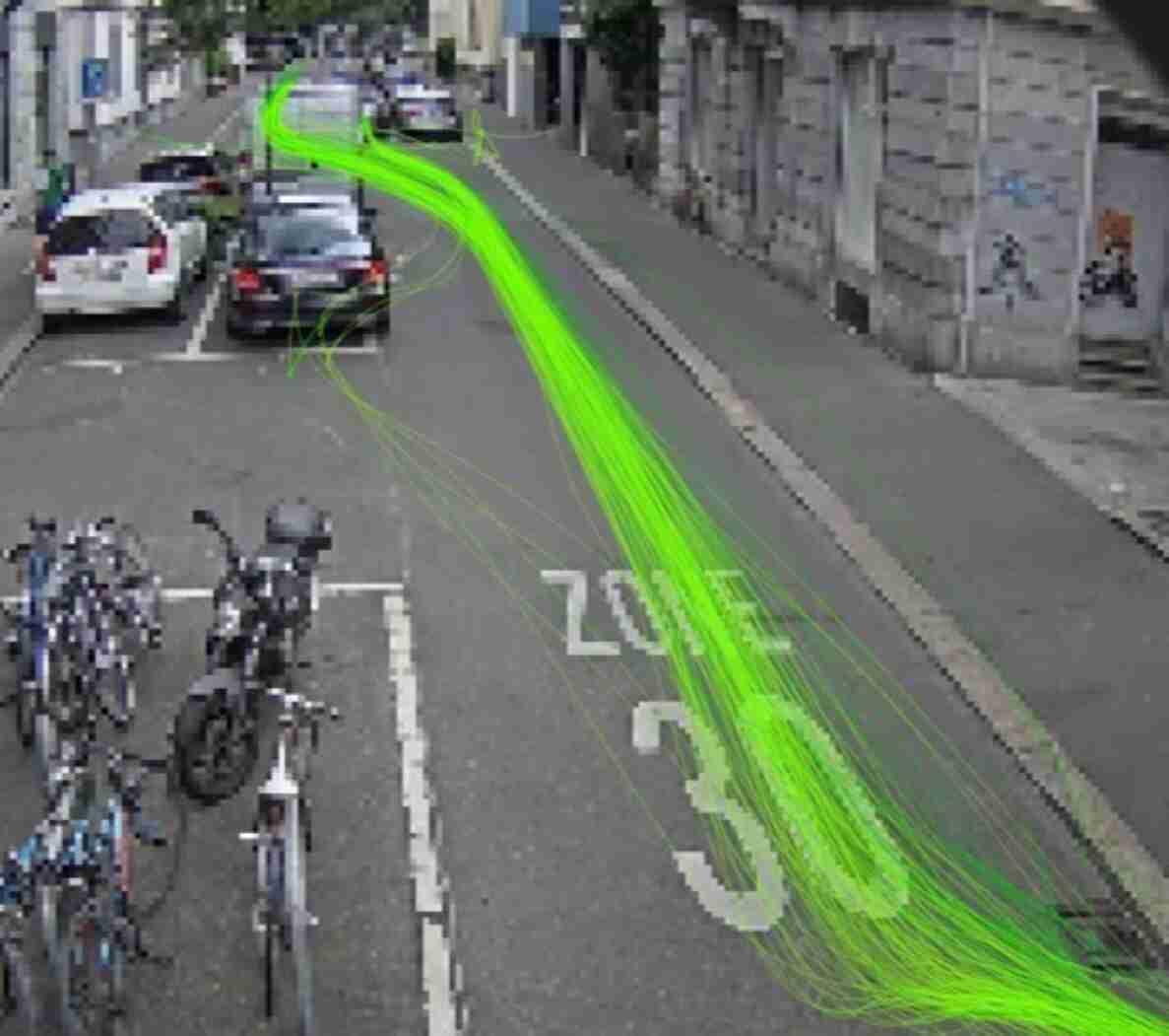 Cramerstrasse mit Fahrbahnmarkierung «Zone 30», grün eingezeichnete Fahrspuren zur Verkehrsmessung zeigen Bewegungslinien der Fahrzeuge entlang der Strasse. Am rechten Fahrbahnrand parkierte Autos, links davon ein Fahrradabstellplatz mit mehreren angeketteten Velos auf dem Trottoir. Schmale Gasse mit Häuserfassaden beidseitig, kein Gegenverkehr sichtbar.